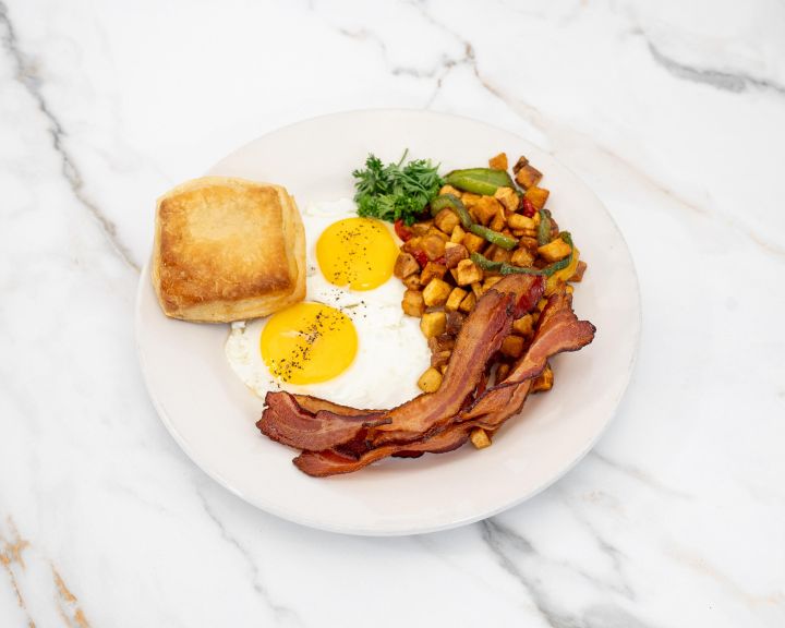 Two eggs with bacon, home fries and a buttermilk biscuit